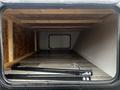Interior view of a 2022 Aspen Trail trailer showing wooden framing and a clean floor with a hooked chain and bar visible on the surface