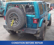 A blue 2020 Jeep Wrangler with a spare tire mounted on the back and visible wear on its tires and body