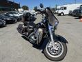 A 2004 Harley-Davidson FLHTCUI motorcycle with a black and brown color scheme featuring a large front fairing and two comfortable seats.