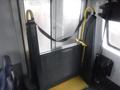 Interior view of a 2016 Chevrolet Express showing a foldable accessibility ramp with yellow handrails and a metallic mesh barrier