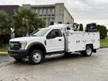 A white 2017 Ford F-550 with service body and equipment mounted in the truck bed