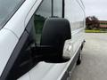 Close-up of the side mirror of a 2017 Ford Transit with a black casing and integrated light visible on the side