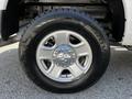 Close-up of a silver alloy wheel and tire from a 2016 RAM 2500 featuring a polished center cap and rugged tread pattern