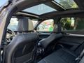 Interior view of a 2020 Alfa Romeo Stelvio featuring black leather seats and a panoramic sunroof
