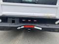 A rear view of a 2003 Ford F-450 SD showing the tailgate with the word STALL partially visible and a hitch receiver below with red and white reflectors on the bumper