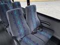 Interior view of a 2020 Chevrolet Express showing two grey upholstered seats with blue and teal patterns and seatbelts