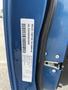 A blue 2022 Dodge Charger showing its vehicle identification number sticker attached to the door frame