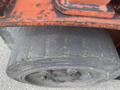 A close-up of a large, industrial truck tire with visible tread patterns and markings on the sidewall indicating it is a 2010 Toyota 7FGGU25 tire