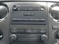 Dashboard controls of a 2016 Ford F-550 featuring audio and climate control buttons and a digital display for time