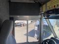 Interior view of a 2012 Ford Econoline with a driver's seat and dashboard visible showing controls and a side window