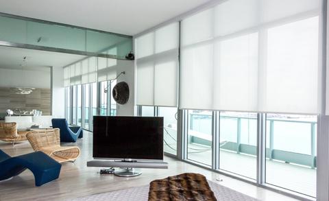 Custom roller blinds in a modern setting providing light filtration and privacy in a stylish manner