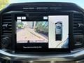 A 2021 Ford F-150 displayed on a digital screen with a rearview and top-down view showing the vehicle's surroundings and safety guidelines