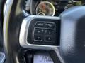 Close up of a steering wheel with control buttons for voice activation and phone functions on the left side