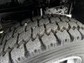 Close-up of a rugged tire from a 2014 Hino 195 showing detailed treads designed for traction and durability