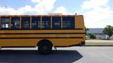 A 2014 Freightliner Thomas diesel school bus, featuring a yellow exterior with black stripes and multiple windows on the side