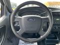 Steering wheel of a 2010 Ford Ranger with a prominent Ford logo and dashboard gauges visible in the background