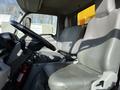 Interior of a 2017 Hino 155 truck showing the driver's seat and steering wheel with a fire extinguisher on the floor