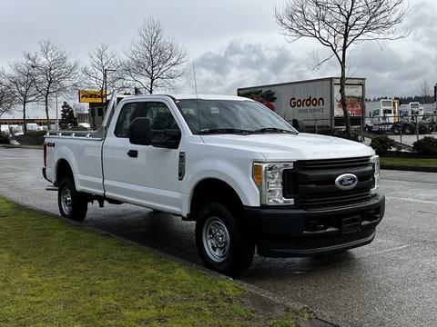 A 2017 Ford F-250 pickup truck in white with a regular cab and a truck bed parked on a road