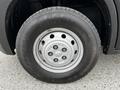 Close-up of a silver wheel on a 2021 RAM Promaster with a black tire featuring an all-season tread pattern