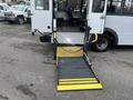 A 2017 Chevrolet Express with a lowered wheelchair ramp at its rear showing a textured surface and safety stripes