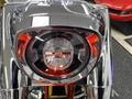 Close-up of the headlight of a 2024 Harley Davidson Fat Boy featuring a chrome finish and red accents