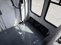 Interior of a 2010 Ford Econoline featuring a gray floor with a seatbelt attached and black storage bags on the side