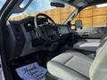 Interior of a 2011 Ford F-450 SD featuring a steering wheel dashboard and front seats with a floor mat that says Thank You