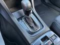 A close-up view of the gear shift and center console of a 2021 Subaru WRX featuring a black leather boot and red stitching