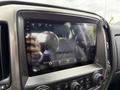 A close-up of the touchscreen display in a 2017 Chevrolet Silverado 1500 showing the time and music controls along with a navigation interface