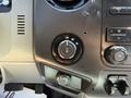 Close-up of the dashboard controls in a 2014 Ford F-250 SD showing the four-wheel drive selector knob and other buttons for climate and audio settings