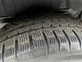 Close-up of a worn tire from a 2014 Ford Transit Connect showing tread patterns and dirt accumulation on the surface