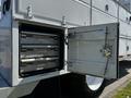 A 2004 Freightliner M2 with an open rear storage compartment revealing three metal drawers inside