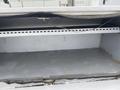 Empty compartment area of a 2003 Ford F-450 SD with a metal interior and a sliding track at the top