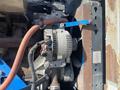 A close-up view of the engine components of a 1997 Genie S-65 4X4 including an alternator with attached wiring and a visible fan