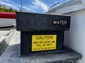 A rectangular black water tank labeled "WATER" with a yellow caution sign indicating to drive with the tank full or empty and to not fill above 75 PSI