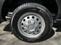 Close-up of a silver rim with six bolts and a black tire labeled Maxxis on a 2021 Ford Transit