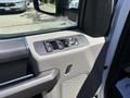 The interior door panel of a 2020 Ford F-350 SD featuring controls for windows and mirrors with a textured finish