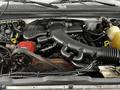 The image shows the engine compartment of a 2008 Ford F-450 SD featuring a large black engine cover and several connected components including hoses and a red part