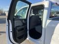 A 2018 GMC Sierra 1500 with the passenger side door open showcasing the interior seating and control panel