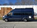 A 2017 Ford Transit van with a dark blue exterior features a roof rack and large windows on the side