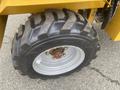 A close-up view of a black and silver tire on a 2024 AGT KRW 23 Mini loader featuring deep treads and a central hub with bolts