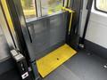 A 2018 Chevrolet Express wheelchair lift featuring a yellow platform and a black mesh barrier designed for accessibility