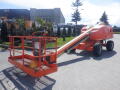 A 2008 JLG Boom Lift with an orange platform and extended arm parked on a surface with visible wheels and control panel on the platform