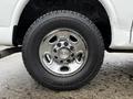 A close-up of a chrome wheel on a 2009 Chevrolet Express featuring a distinctive Chevrolet logo in the center and a rugged tire design