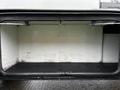 A 2013 Ford F-650 empty storage compartment with a black base and white interior walls featuring metal brackets for securing items inside