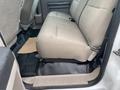 Interior view of the rear bench seat in a 2009 Ford F-450 SD featuring light gray upholstery and a black floor mat