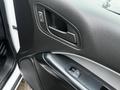 The interior door panel of a 2018 Chevrolet Colorado featuring a handle and window control buttons