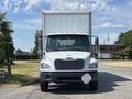 A white 2015 Freightliner M2 106 truck with a boxy cargo area facing forward and distinctive grille features