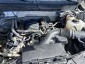 A close-up view of a 2012 Ford F-150 engine compartment showing various components including hoses and the engine block