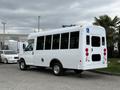A white 2013 Chevrolet Express van with a wheelchair access sign on the rear and large windows on the side